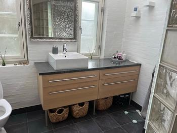 Badeværelsesmøbel med skuffer og vask lyse træfronter og mørk bordplade