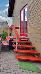 Udendørs trappe med gelænder metal og træ rød