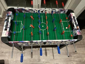 Bordfodboldbord med grøn spilleflade og blå og røde spillere