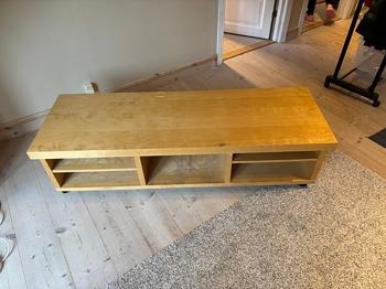TV bænk i lyst træ med hjul.