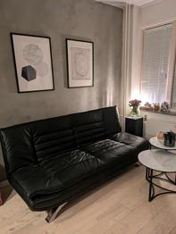 Sort sovesofa i imiteret læder