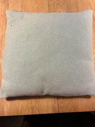 Lys turkis pyntepude med strikoverflade