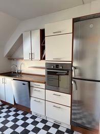 Køkken med hvide skabe og træbordplade